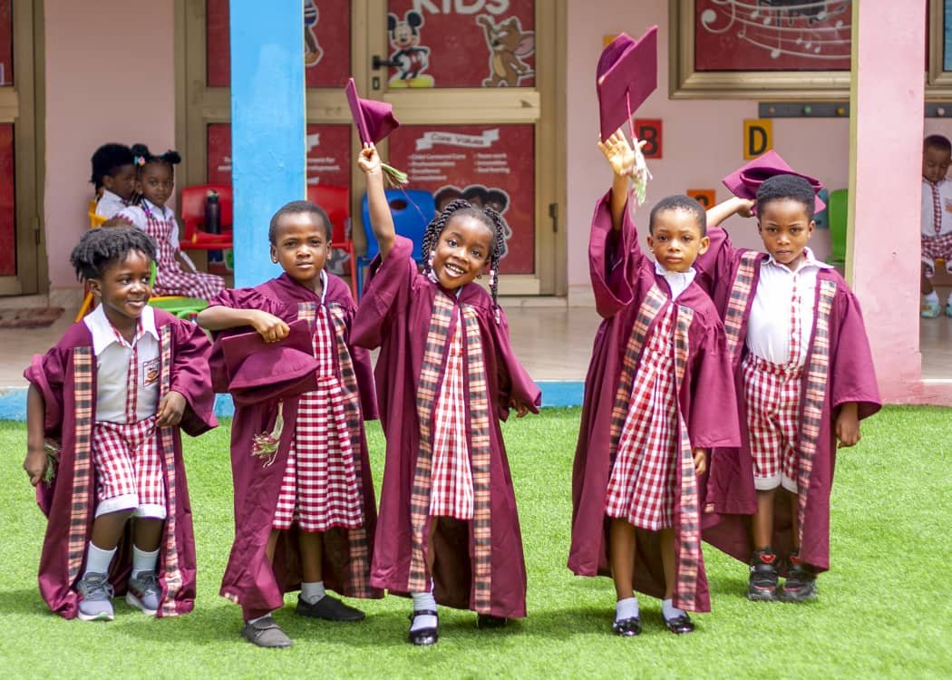 Graduating pupils celebrating and waving their caps